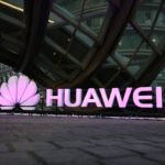 people walk past an illuminated logo for Huawei at a launch event for the Huawei MateBook in Beijing. A Chinese court notice says homegrown tech giant Huawei has won a patent infringement lawsuit against South Korea smartphone rival Samsung. The notice released Thursday, Jan. 11, 2018 said the court ruled in the Chinese companyÄôs favor over two patents involving fourth generation phone technology.(AP Photo/Mark Schiefelbein, File)